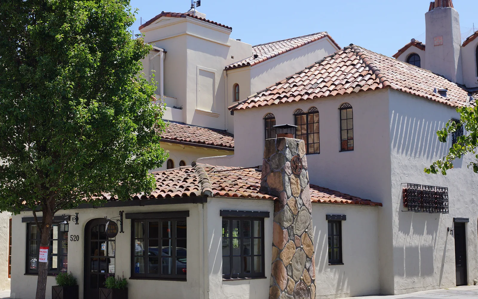 Tree-lined street in Palo Alto's Ramona Street Architectural District with historic commercial buildings