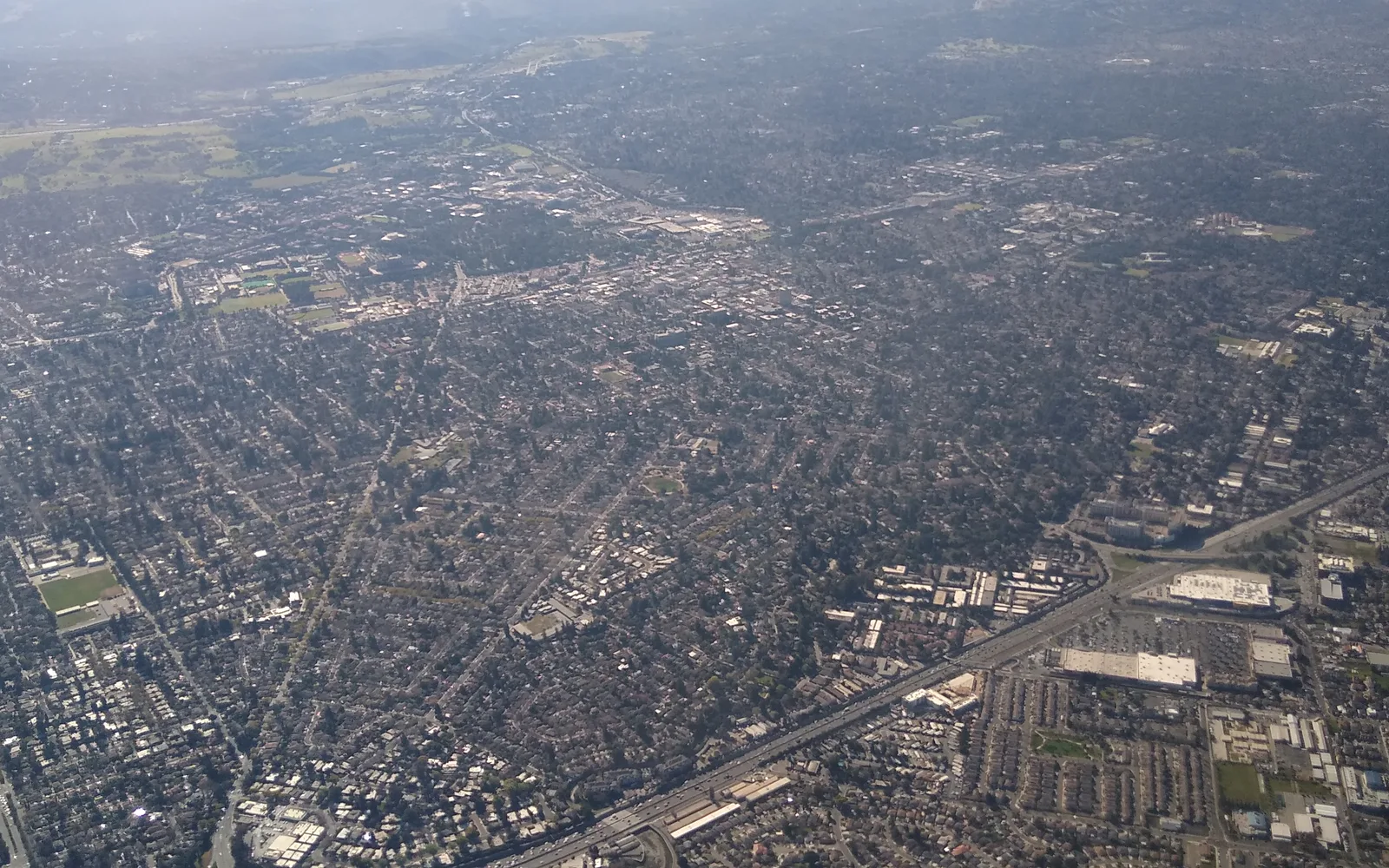 Aerial view of Palo Alto showing residential neighborhoods, green spaces, and surrounding Silicon Valley landscape